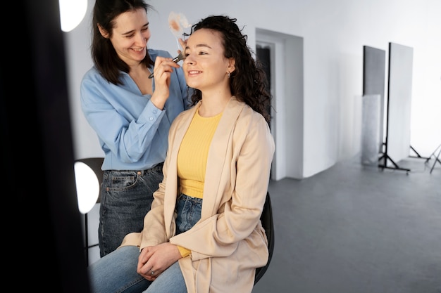 Make up artist getting model ready for photoshootin