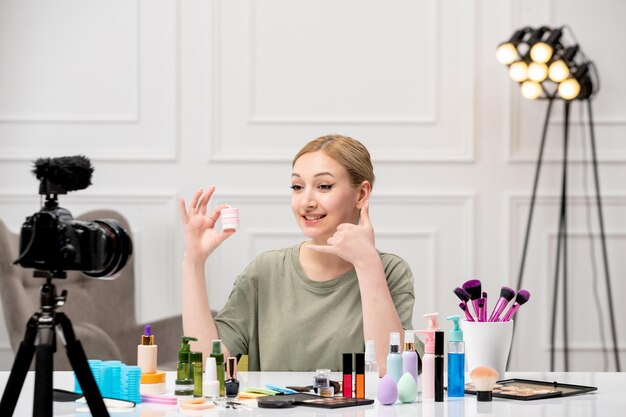 Makeup blogger cute pretty young girl recording makeup tutorial on camera talking