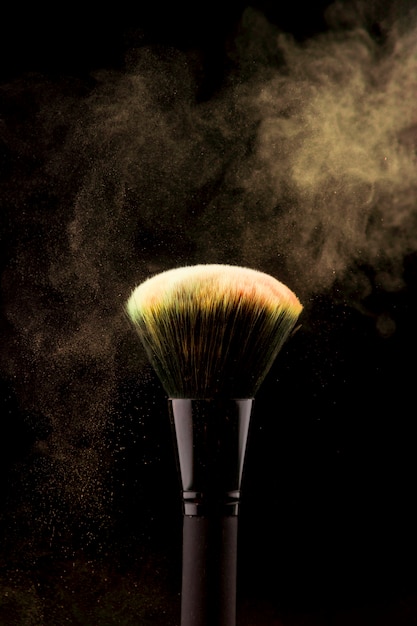 Makeup brush with yellow powder splash