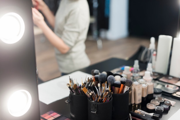 Makeup brushes and cosmetics near mirror