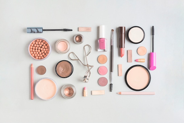 Makeup products arranged in rectangular shape on white backdrop