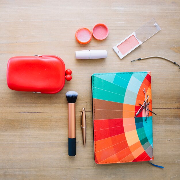 Makeup supplies and bright notebook