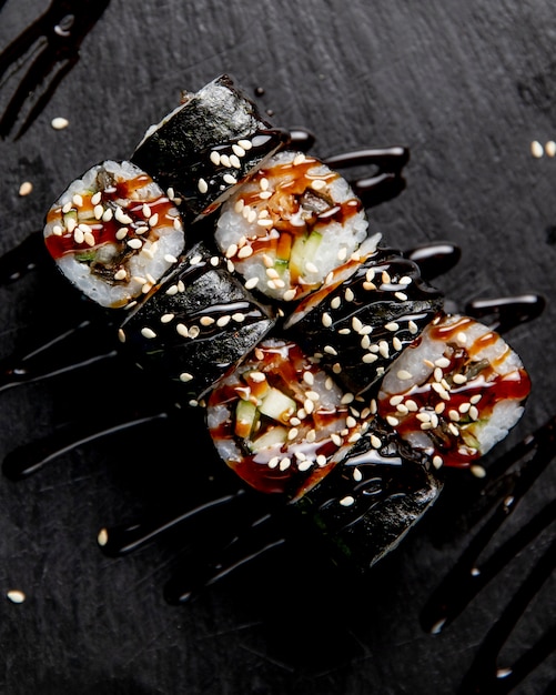 Free Photo maki roll with cucumber served with sauce and sesame seeds