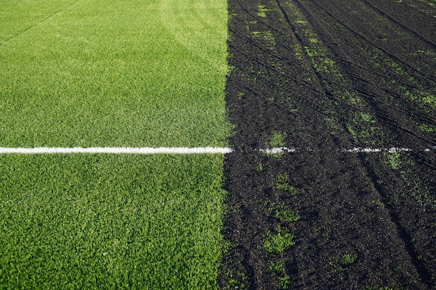 Making off an artificial grass soccer field with green synthetic grass surface and rubber granules