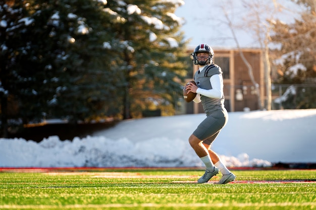 Free photo male american football player in uniform training on the field