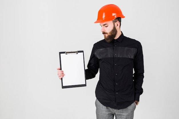 Free photo male architect looking at white paper on clipboard