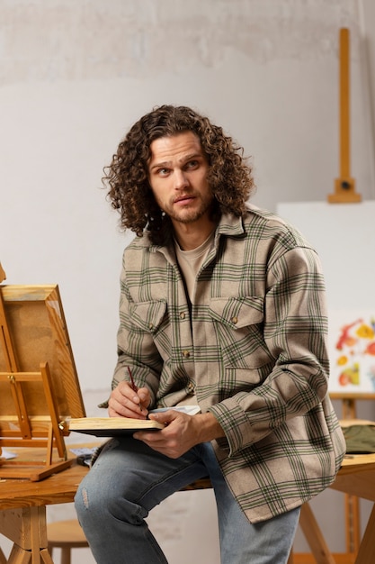 Male artist painting at studio with watercolors