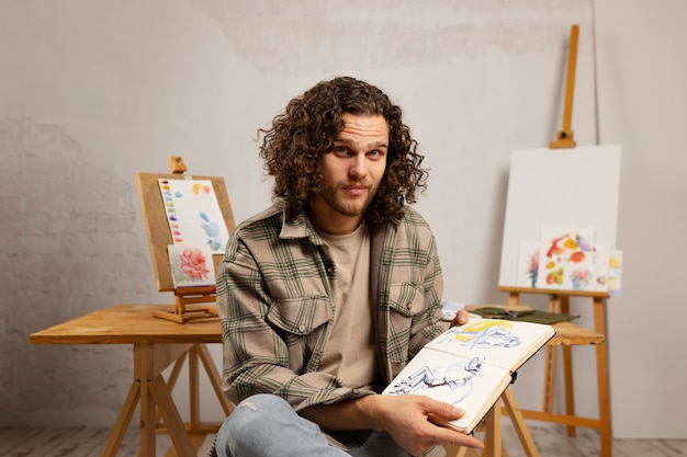 Free photo male artist painting at studio with watercolors