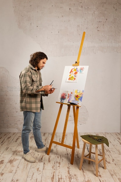 Male artist painting at studio with watercolors