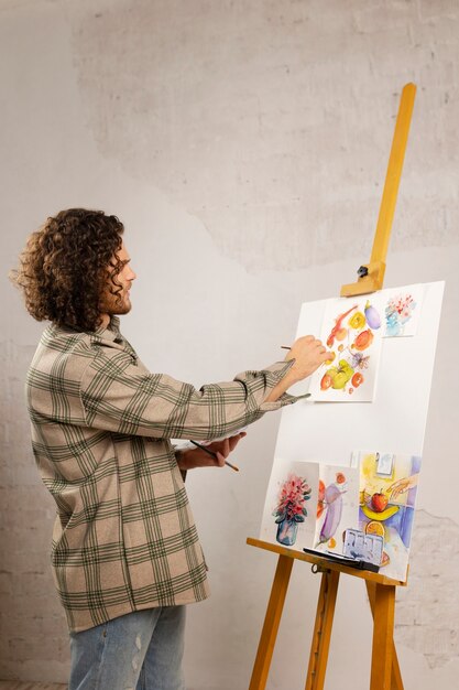 Male artist painting at studio with watercolors