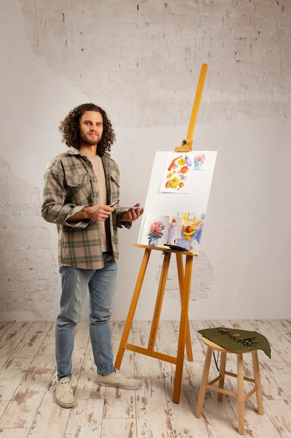 Male artist painting at studio with watercolors