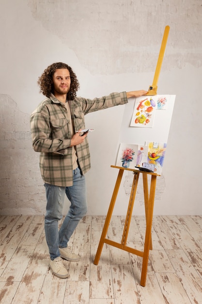 Free photo male artist painting at studio with watercolors