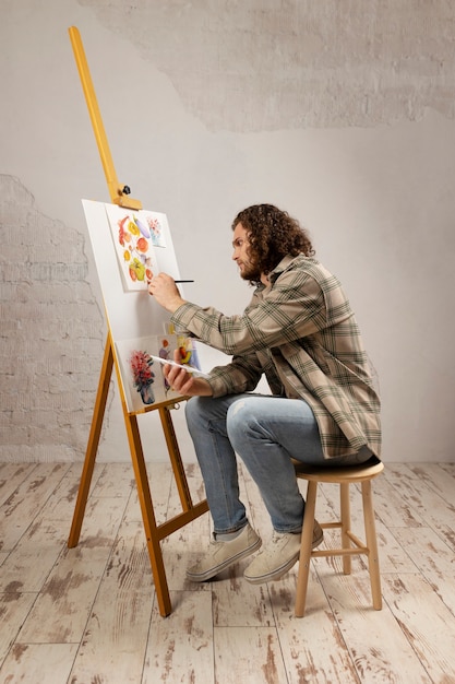 Male artist painting at studio with watercolors