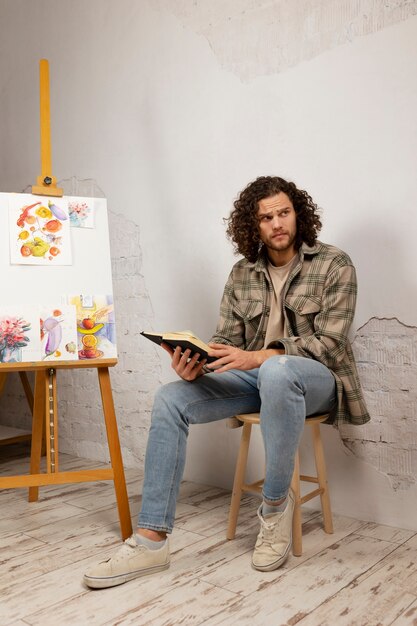 Male artist painting at studio with watercolors