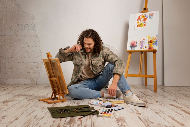 Male artist painting at studio with watercolors