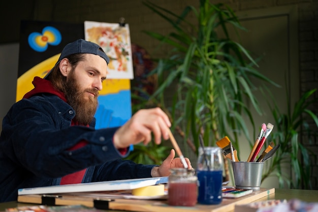 Male artist painting with watercolor in the studio