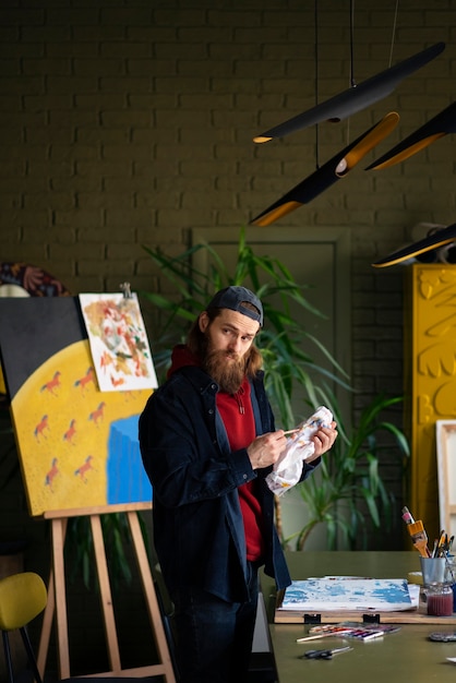 Male artist painting with watercolor in the studio