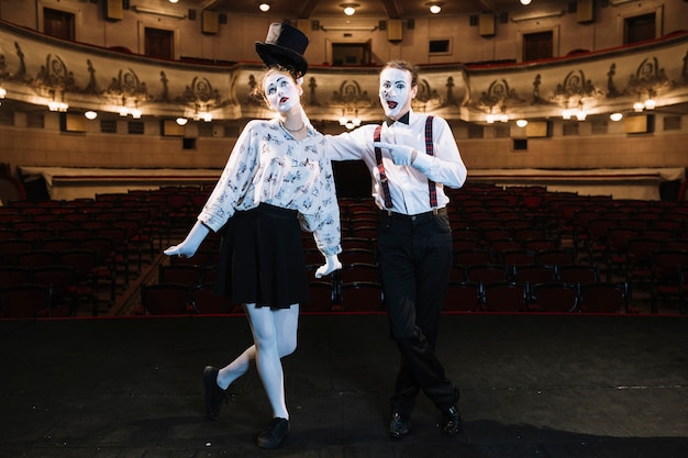 Free photo male artist pointing finger at female mime artist standing on stage