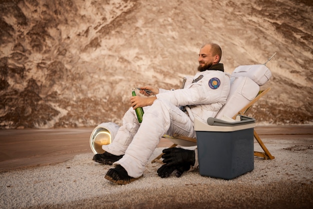 Free Photo male astronaut opening a beer during a space mission on an unknown planet