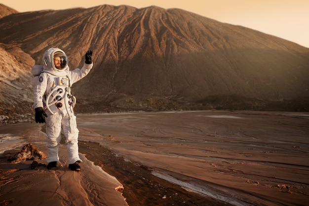 Free photo male astronaut protecting his eyes from the sun during a space mission on another planet