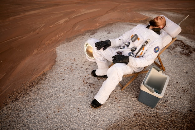 Free photo male astronaut relaxing during a space mission on an unknown planet