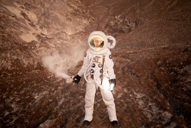 Free photo male astronaut signaling his location during a space mission on an unknown planet