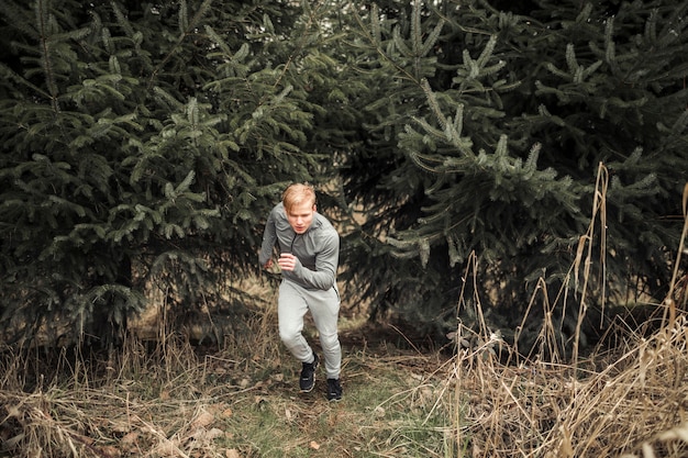 Free photo male athlete running in forest