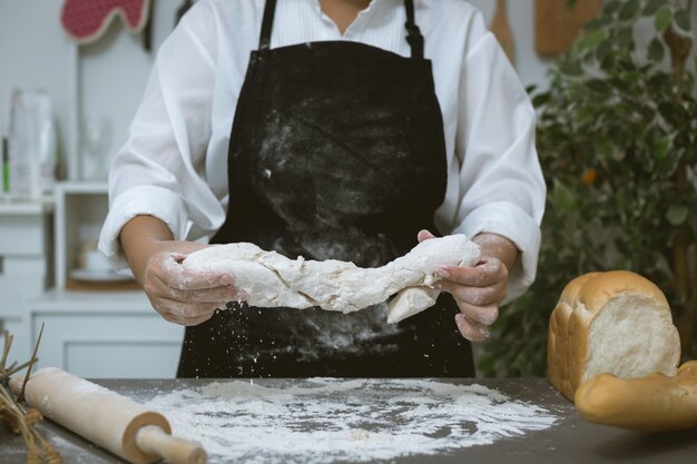 Male baker prepares bread with flour