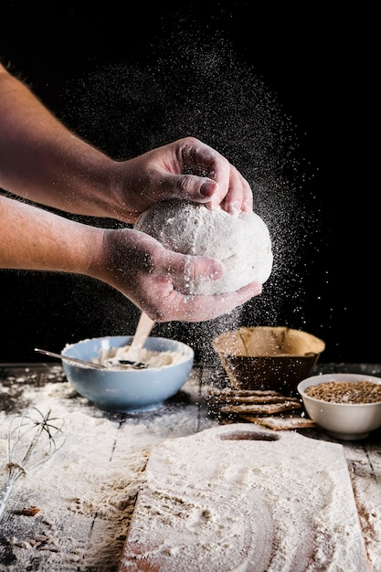 Male baker's hand preparing dough for bread