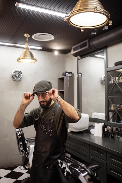 Free photo male barber sitting at his shop