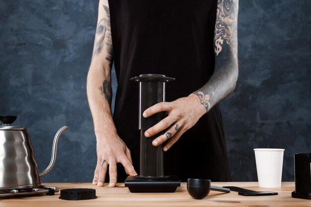 Male barista brewing coffee. Alternative method aeropress.