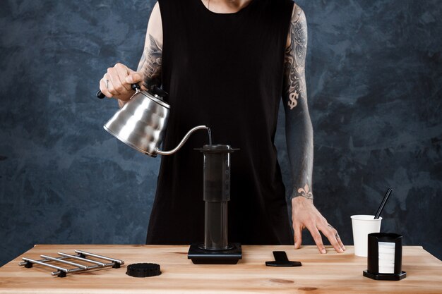 Male barista brewing coffee. Alternative method aeropress.