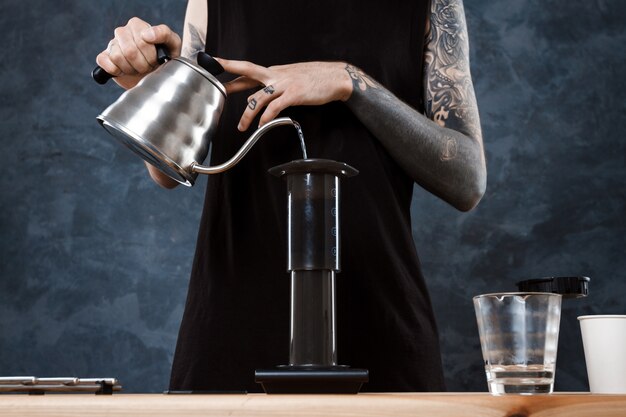 Male barista brewing coffee. Alternative method aeropress.