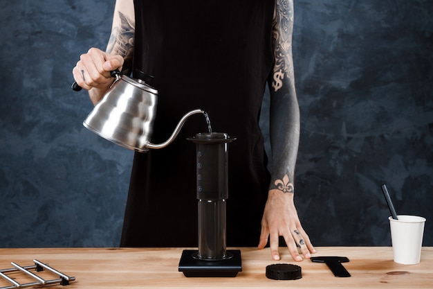 Male barista brewing coffee. Alternative method aeropress.