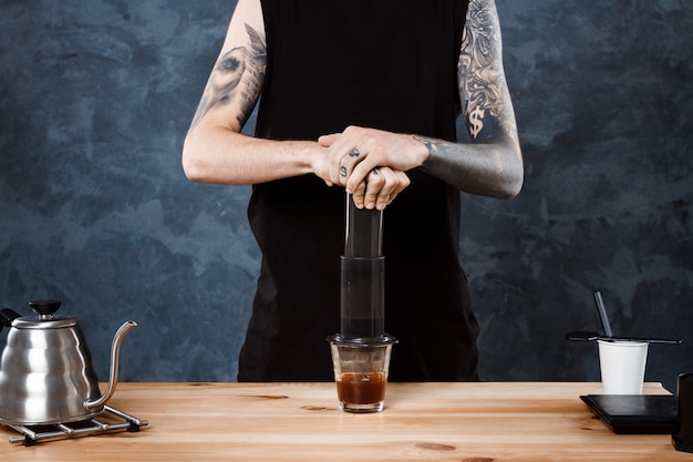 Male barista brewing coffee. Alternative method aeropress.