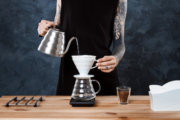 Free photo male barista brewing coffee. alternative method pour over.