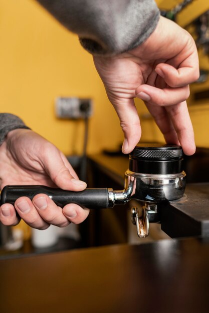 Male barista using professional coffee machine cup