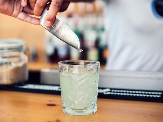 Male bartender adding ice with scoop