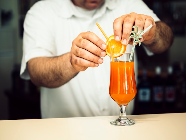 Free photo male bartender decorating exotic cocktail