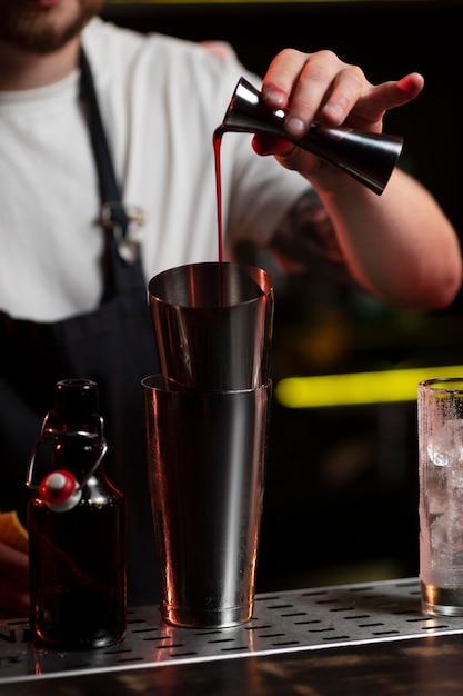 Male bartender making a cocktail with a shaker