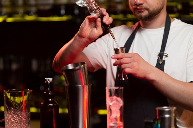 Male bartender making a cocktail with a shaker