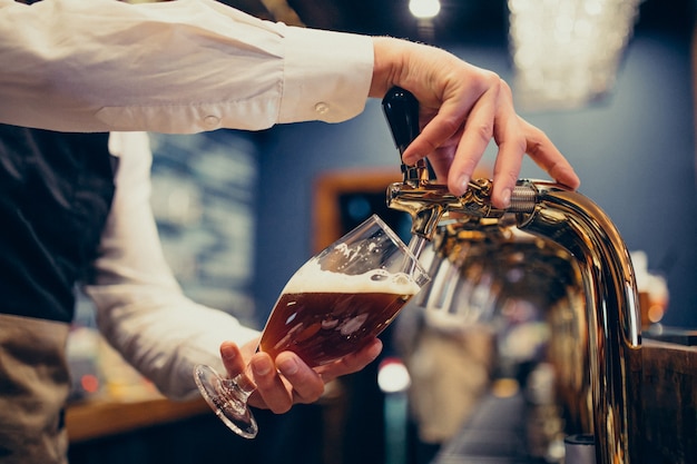 Male bartender pouring beer at a pub