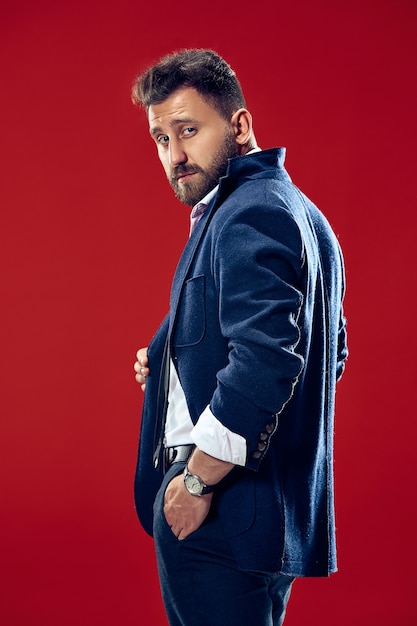 Male beauty concept. Portrait of a fashionable young man with stylish haircut wearing trendy suit