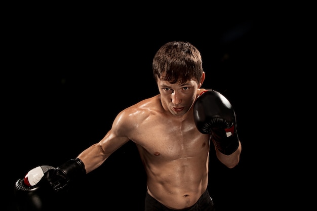 Male boxer boxing on black