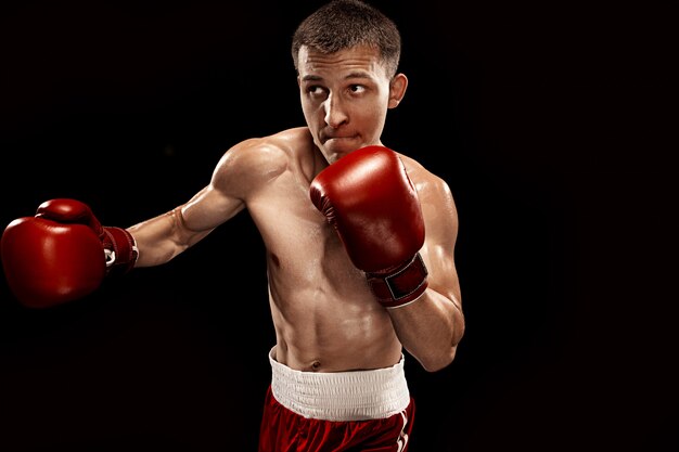 Male boxer boxing with dramatic edgy lighting in a dark studio