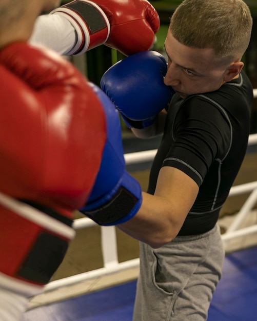 Male boxer practicing in the ring with trainer