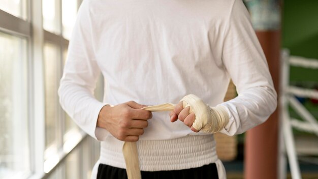 Male boxer wrapping his hands with protective cord