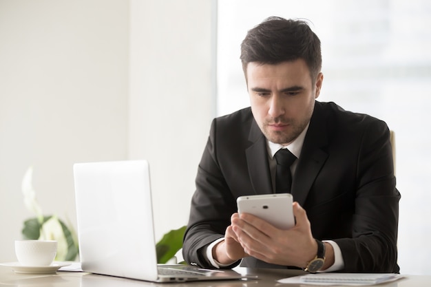 Male business leader browsing online resources using gadgets