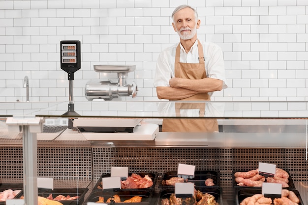 Free photo male butcher posing behind counter.