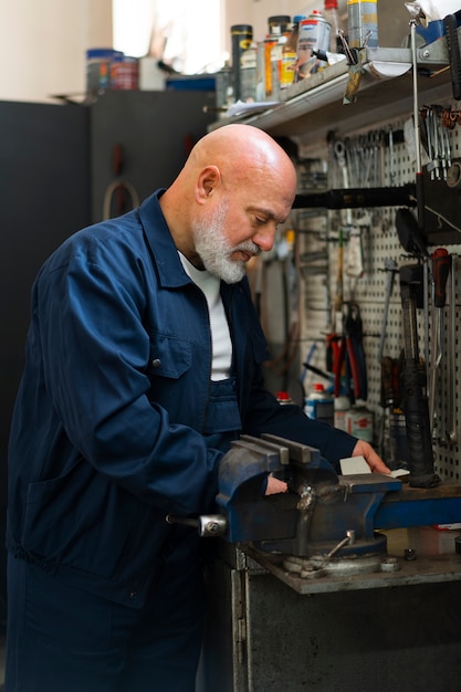 Free photo male car mechanic working in the car repair shop